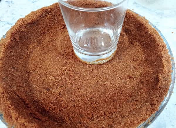 aplastando la masa de galletas al fondo del molde