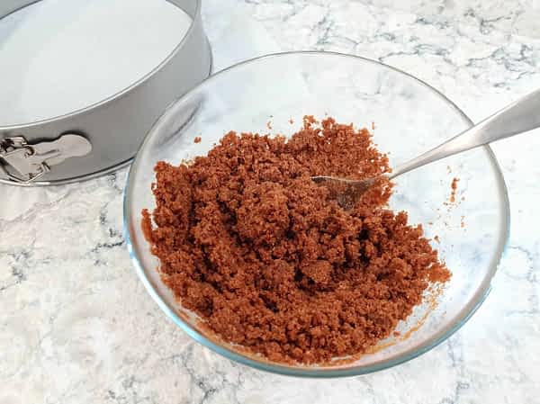 Mezclar las migas de galleta con el azúcar y la mantequilla derretida. la masa para la base de galletas