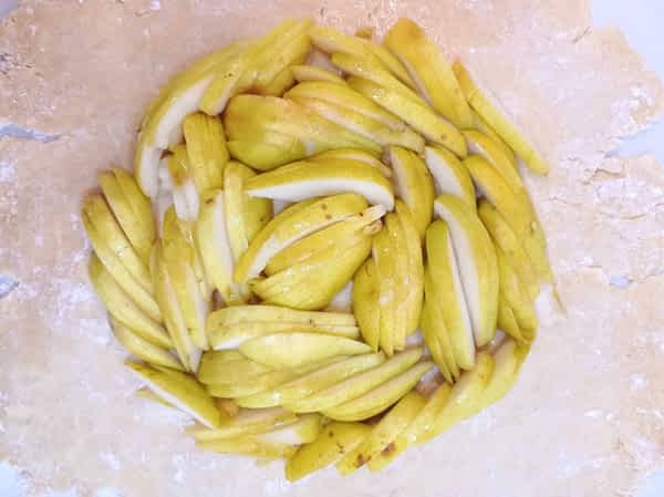 las peras rebanadas encima de la masa quebrada