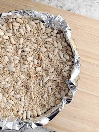 llenar la masa en el molde con frijoles y arroz secos