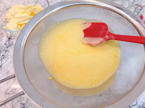 la salsa de limón pasando por el colador