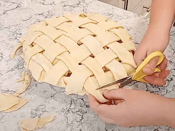 Cortar las sobras de masa alrededor del pie. Dejar ~2 centímetros de masa extendida. cortar la masa que sobra