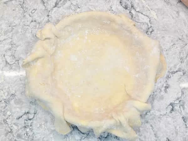 Poner una masa en el molde, dejándola extender unos centímetros por todos lados. meter la masa de la base en el molde