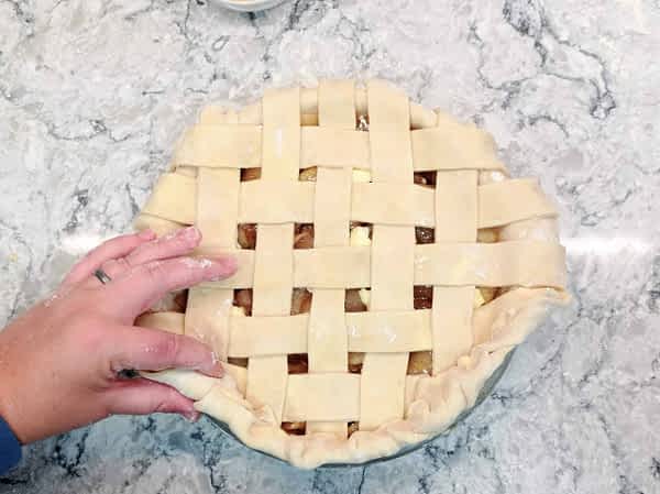 Doblar hacia el centro la masa del borde, presionando las dos piezas de masa juntas. doblar masa hacia adentro