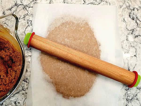 aplanando la masa entre papeles de horno