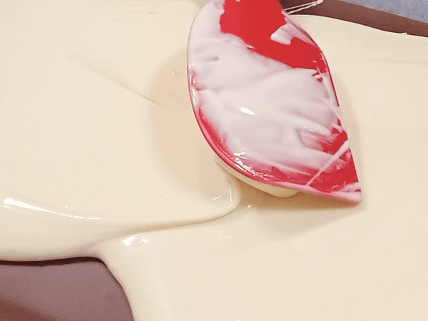 esparciendo el chocolate blanco encima de la capa de chocolate negro