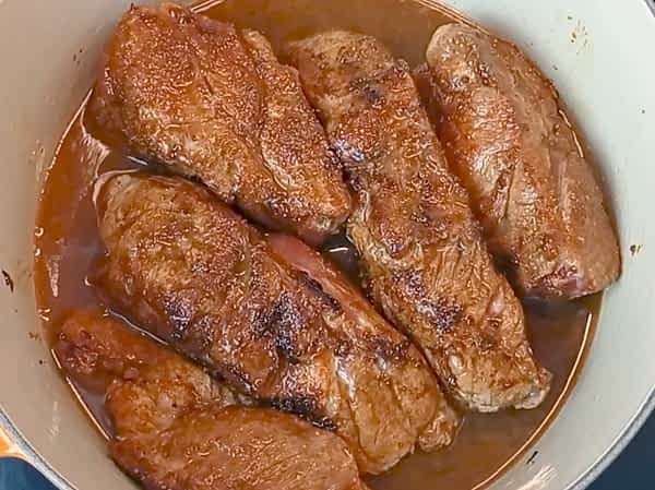 cerdo dorado más los líquidos en la olla