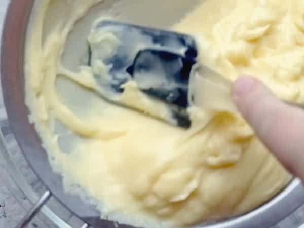 presionando la crema por un colador con una espátula