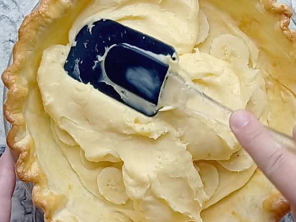 esparciendo la última capa de crema pastelera en el pay