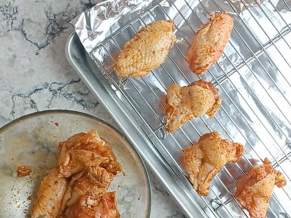 las alitas colocadas encima de la rejilla en la bandeja