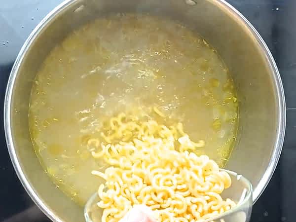 vertiendo los fideos en la sopa