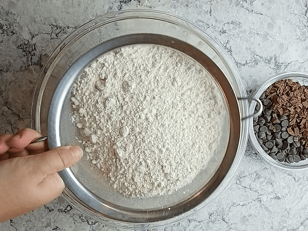 tamizando la harina en la masa de magdalenas