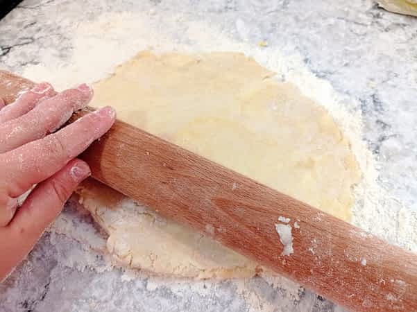 aplanando la masa de pie con el rodillo