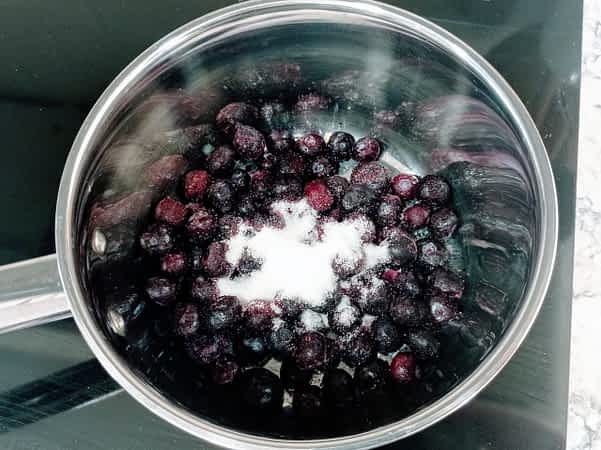 arándanos y azúcar en una olla
