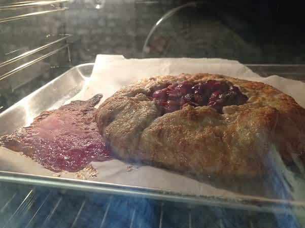 el galette de cerezas en el horno goteando su zumo en la bandeja