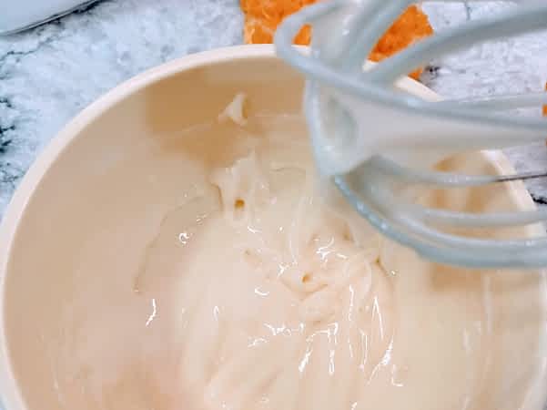 el glaseado de naranja con una batidora de varillas