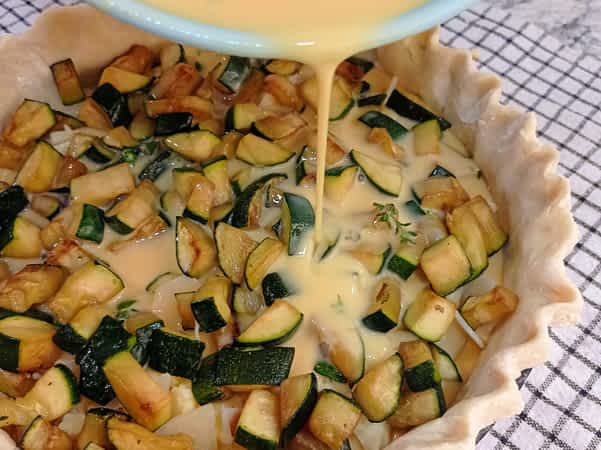 vertiendo la mezcla de huevos en la masa del quiche