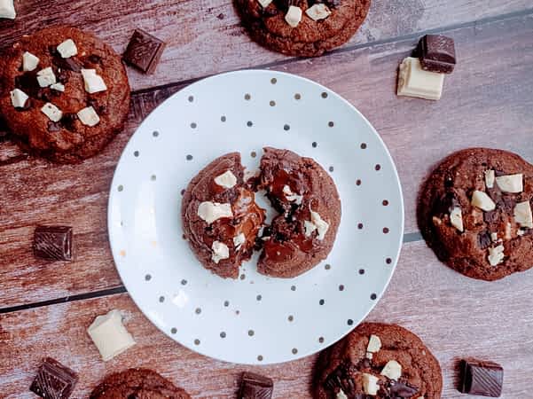 un plato con una galleta de doble chocolate partida a mitades