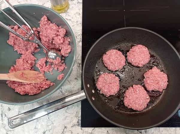 cocinando las salchichas de desayuno en la estufa