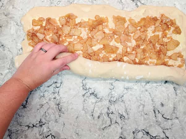 enrollando la masa con el relleno de manzana