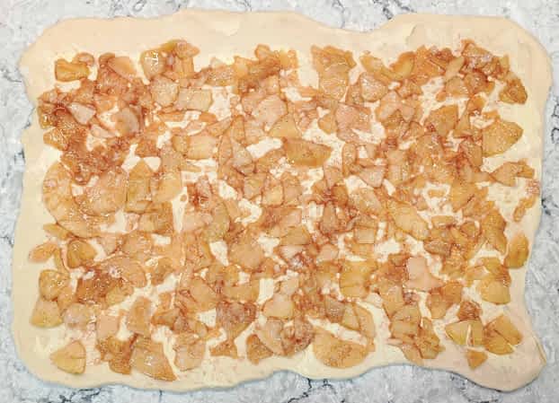 la masa con el relleno de manzana extendido encima