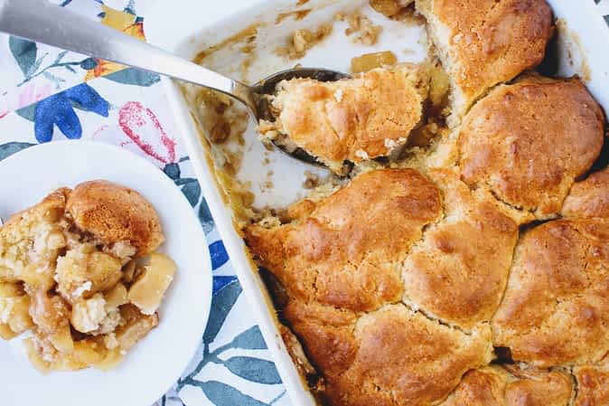 el molde con cobbler al lado de una porción en un plato