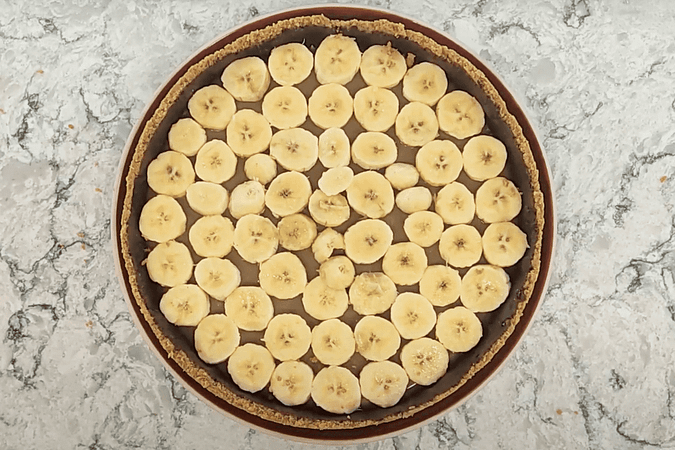 una capa de plátanos cortados encima de la salsa de caramelo