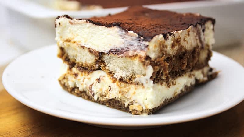 un trozo del mejor tiramisu facil sin huevo en un plato